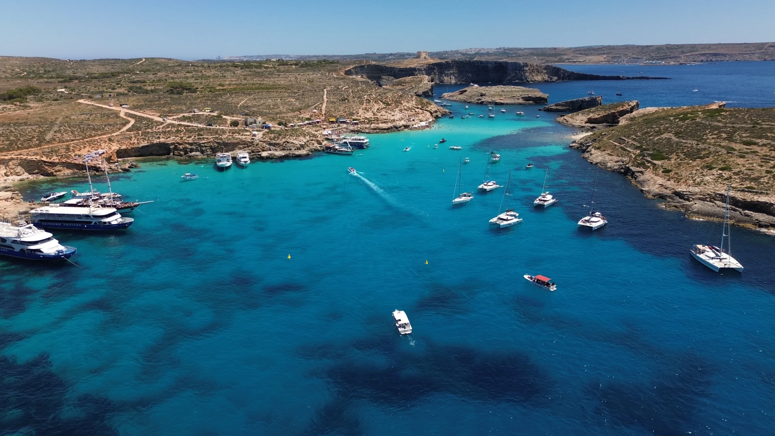 Aerial view of Malta's Blue Lagoon in Comino crowded with ferry boats and day-trip catamarans