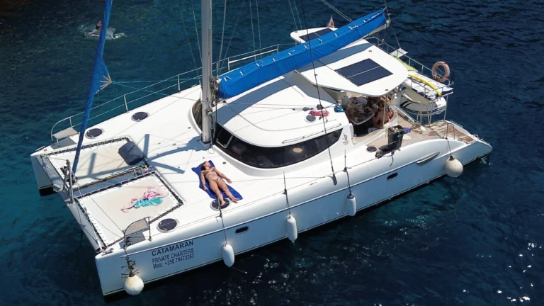 Chiquita catamaran anchored with a guest sunbathing on the trampoline