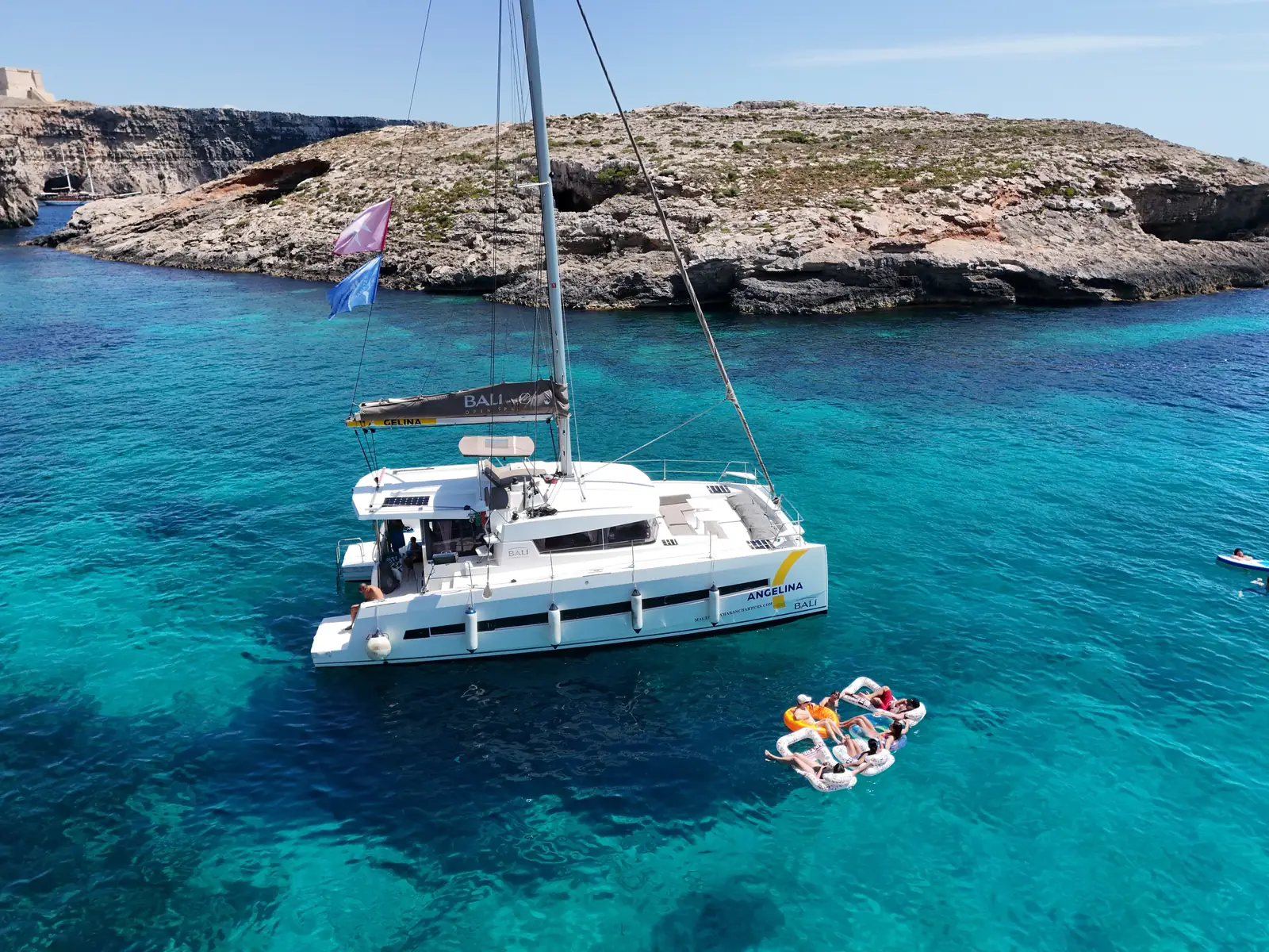 Der Katamaran Angelina Mia Bali 4.0 ankerte vor Comino, die Gäste entspannten sich auf einer schwimmenden Matte.