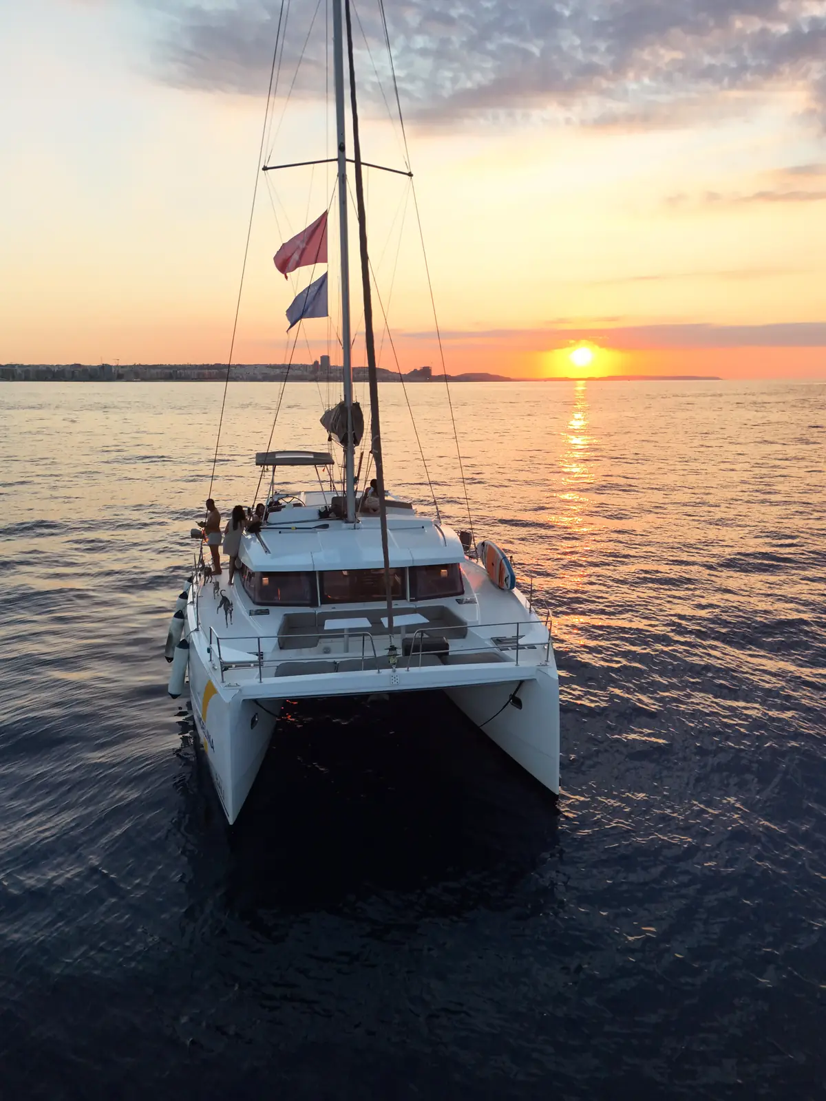 Angelina Mia catamaran at sea at sunset off the coast of Malta