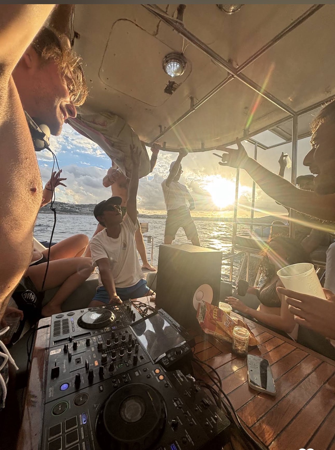 Guests dancing to a DJ at sunset on a private boat charter in Malta